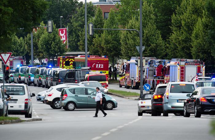 Police cars and fire trucks stand near a shopping centre in which a shooting was reported in Munich, southern Germany, Friday, July 22, 2016. Situation after a shooting in the Olympia shopping centre in Munich is unclear.  (Matthias Balk/dpa via AP)
